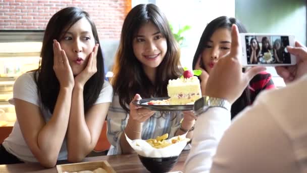 Friends group of Asian people, one male taking photos of female friends at restaurant — Stockvideo