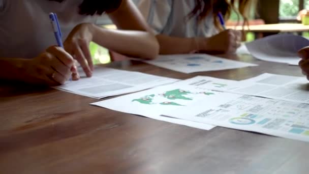 Close-up van mensen die schrijven en hun presentatiepapieren op tafel voorbereiden — Stockvideo