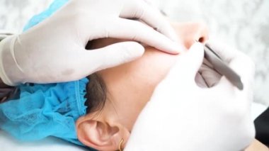 Young Asian woman getting pimples, acnes removed by beautician at beauty clinic