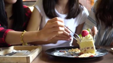 Friends group of female enjoy eating cake and having a conversation at cafe and restaurant