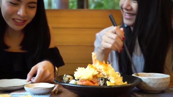 Two Asian female friends eating and having meal together. Women enjoying good time at restaurant — Stock Video