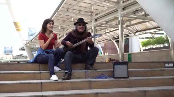 Street musician duo of female singer and male guitarist performing on street — Vídeo de Stock