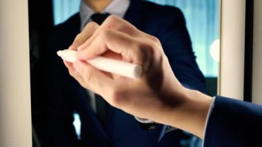 Smart business man writing the word Product on the mirror board