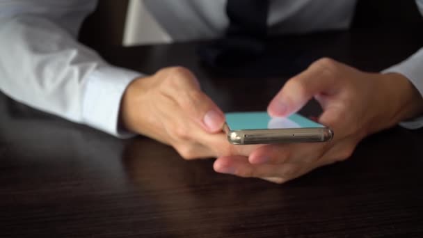 Young business man in suit and tie using a mobile phone on the working desk — Stockvideo