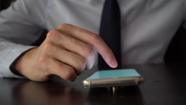 Young business man in suit and tie using a mobile phone on the working desk — Stockvideo