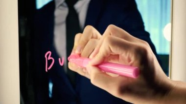 Smart business man writing the word Business on the mirror board