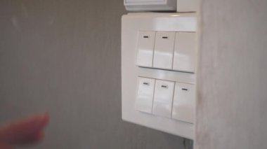 Close up of one persons hands pressing the light switch off - Saving global environment and power
