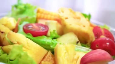 Organic green salad with various kinds of fruits in rotating macro shot - Healthy life
