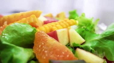 Organic green salad with various kinds of fruits in rotating macro shot - Healthy life