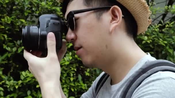 Orbit circle shot of young male travel photographer tourist taking photos in nature scenery — Stockvideo