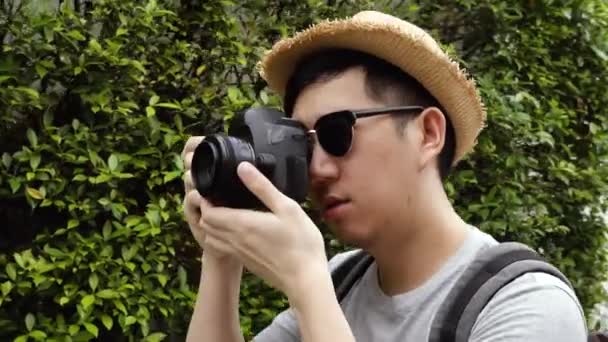 Orbit circle shot of young male travel photographer tourist taking photos in nature scene — Stockvideo