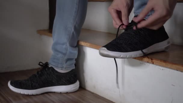 Closeup of one persons feet tying shoelaces or shoestrings up at home stairs — Αρχείο Βίντεο