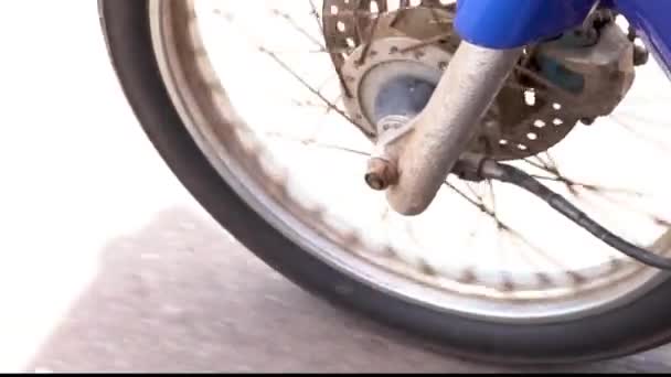 Front wheel of Motorbike spinning and moving forward on the road. Automobile engine running closeup — Vídeo de Stock
