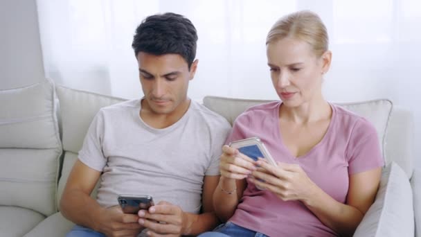 Pareja sentados juntos usando smartphone — Vídeos de Stock