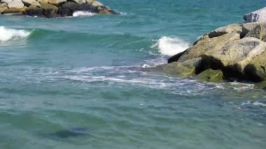 Güçlü dalgaların Rayong, Tayland, Asya 'da kayalık bir plaja çarptığı manzara videosu.