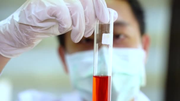 Κοντινό πλάνο του Ασιάτη επιστήμονα σε λευκή φιάλη εργαστηρίου με κόκκινο χημικό διάλυμα. Χημεία, Επιστήμη, Βιολογία, Τοξικολογία, Έρευνα και Ανάπτυξη — Αρχείο Βίντεο