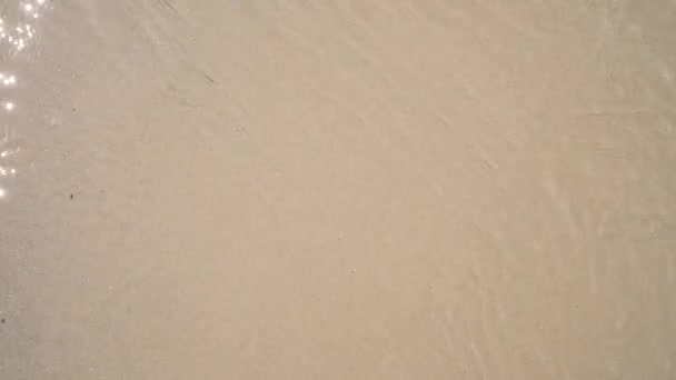Close up vista superior de areia e textura da água do mar e padrão. Abstrato aéreo praia oceano ondas fundo com espaço de cópia — Vídeo de Stock