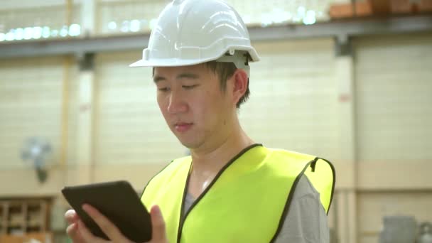 Jeune asiatique mâle ouvrier d'usine à l'aide d'une tablette numérique — Video