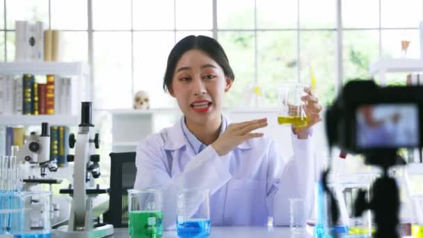 Labcoat 'taki Asyalı kadın laboratuardaki tıbbi araştırma ve bilim deneyleri üzerine çevrimiçi video kaydı yaptı. — Stok video