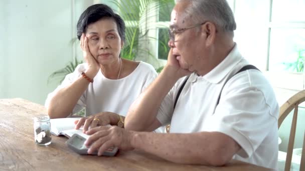 Asijské starší pár zdůraznil a vážné počítání s kalkulačka a mají problém s penězi — Stock video