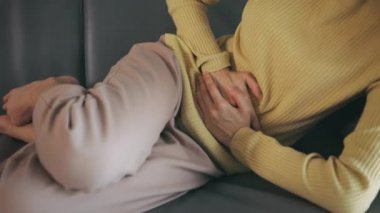 Karın ağrısı çeken genç bir kadın.