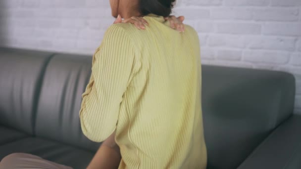 Mujer joven que sufre de dolor en la espalda del cuello — Vídeos de Stock