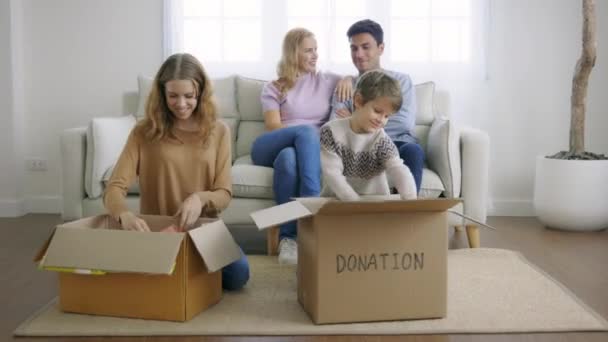 Children keeping things in cardboard box — Stockvideo