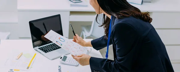 Feliz mujer de negocios asiática escribiendo en el ordenador portátil mientras analiza las estadísticas en la oficina — Foto de Stock