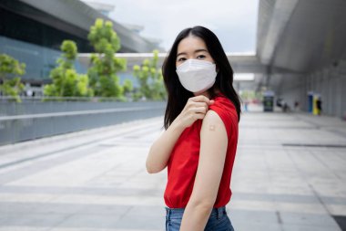 20 'li yaşlardaki Asyalı genç bir kadın Coronavirus' un yayılmasını önlemek için kollarına Covid-19 aşısı enjekte etti.