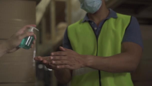 Beskuren ingenjör arbetare med alkoholbaserad handdesinfektionsmedel gel för att tvätta handen medan du arbetar i fabriken lager i ansiktsmask. Hålla handen hygien förhindra Coronavirus Covid 19 pandemic virus spridning — Stockvideo
