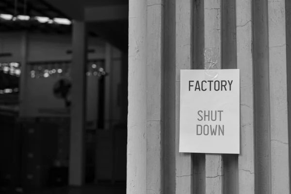 Factory Shut Down sign in front of the factory warehouse. Business shutdown because of economic recession and Coronavirus Covid-19
