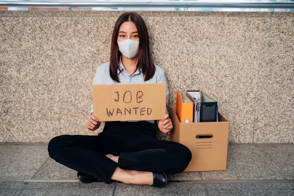 Olycklig kvinna med mask förlorat jobb sitter med plakat — Stockfoto