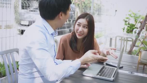 Чоловік і жінка використовують ноутбук у кафе — стокове відео