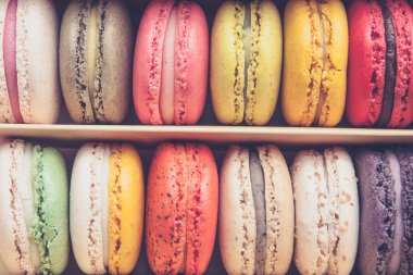 Stack of colorful macaroons stacked up in the box for background - in vintage tone