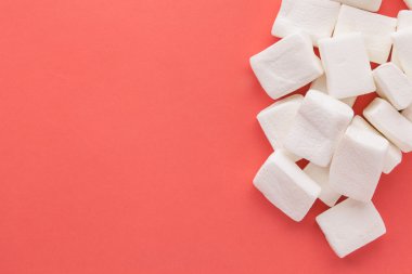 Kırmızı pastel arka planda özgün marshmallow yığını.