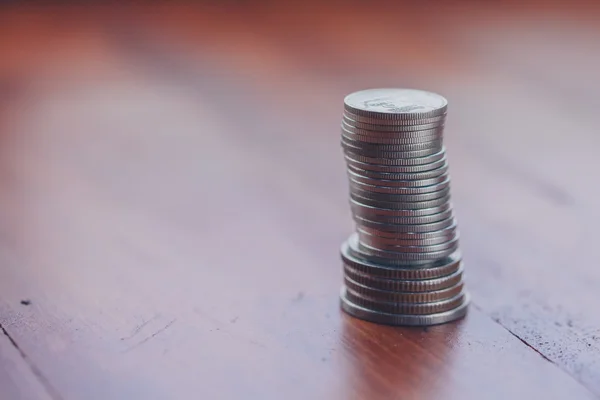 Monedas apiladas en el suelo de madera — Foto de Stock