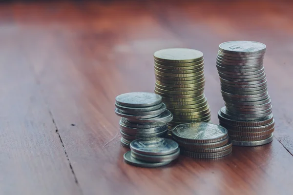 Coins stacking up high on the wood floor — Stock Photo, Image