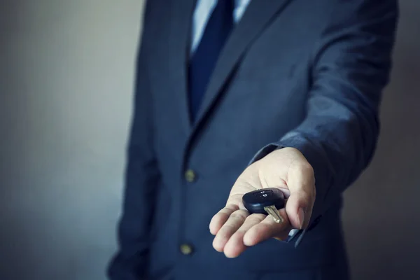 Businessman in suit giving a car key