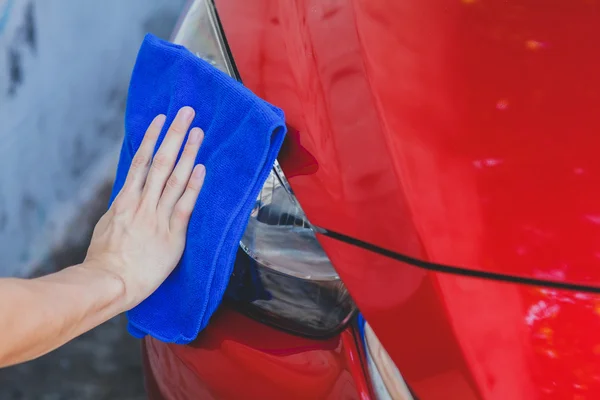 Mladý muž, mytí a utírání auto v outdoorovém — Stock fotografie