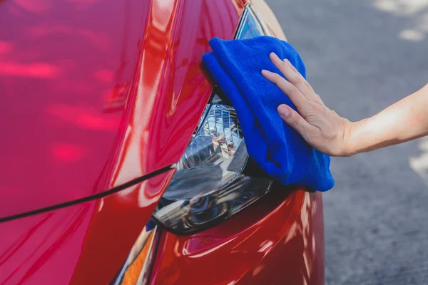 Mladý muž, mytí a utírání auto v outdoorovém — Stock fotografie