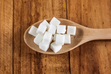 Tahta kaşık ahşap arka plan üzerinde kesme şeker