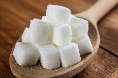 Tahta kaşık ahşap arka plan üzerinde kesme şeker