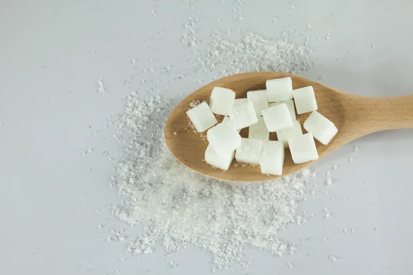 Cubos de azúcar en cuchara con azúcar granulada sobre fondo blanco aislado — Foto de Stock