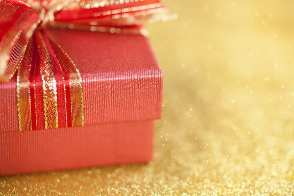 Altın arka plan üzerinde kırmızı hediye kutusu parçası — Stok fotoğraf