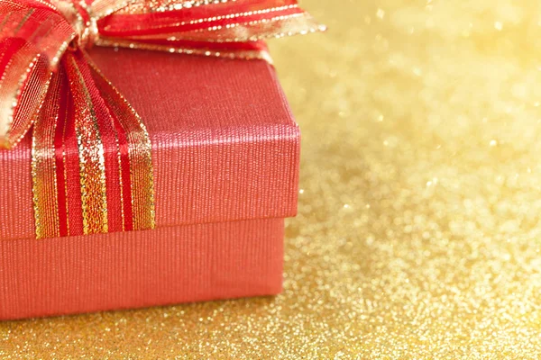 Altın arka plan üzerinde kırmızı hediye kutusu parçası — Stok fotoğraf