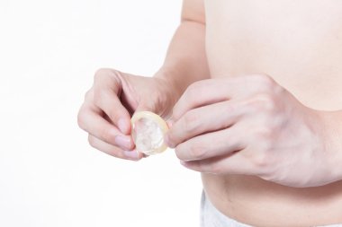 Genç adam prezervatif beyaz izole arka planda - doğum kontrol hapı kullanmak için gidiş / HIV ve AIDS / doğum kontrolü kavramı