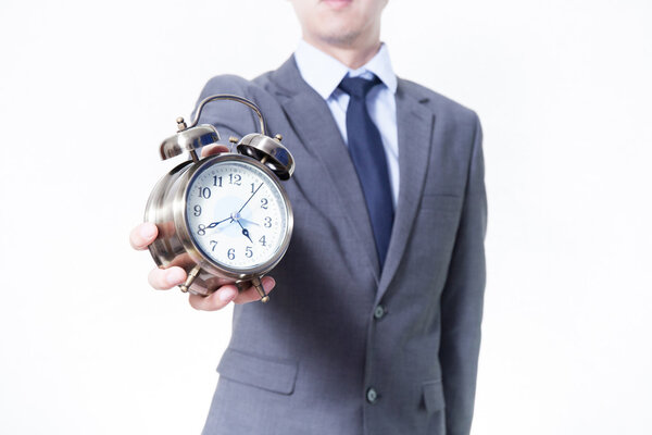 Man in Business Suit holding a clock - on time and business concept