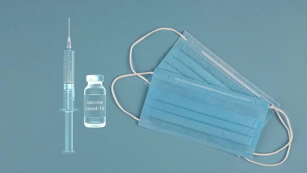 The syringe and vaccine from COVID-19 and the mask is protective. Health care and medical concept.