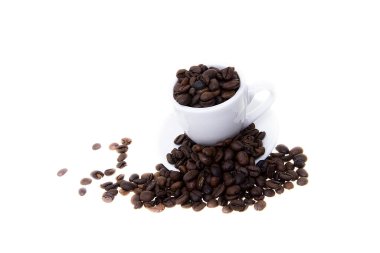 Beyaz arka planda çay tabağı olan kahve çekirdekleri. 