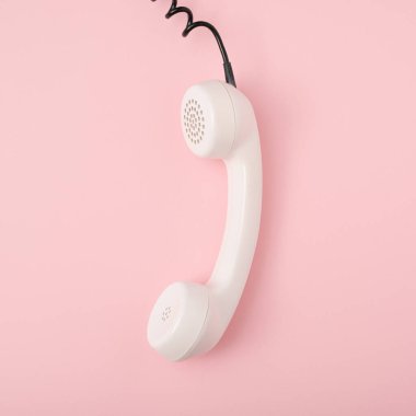 Pastel pembe arka planda klasik telefon. Retro beyaz telefon. Düz konsept